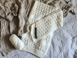 A ball of white yarn and a crochet hook rest on top