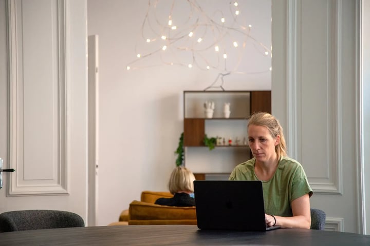 Woman sitting in a modern office on a table with a laptop