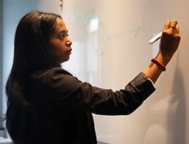 Niyat writing on a whiteboard at the Zooma office