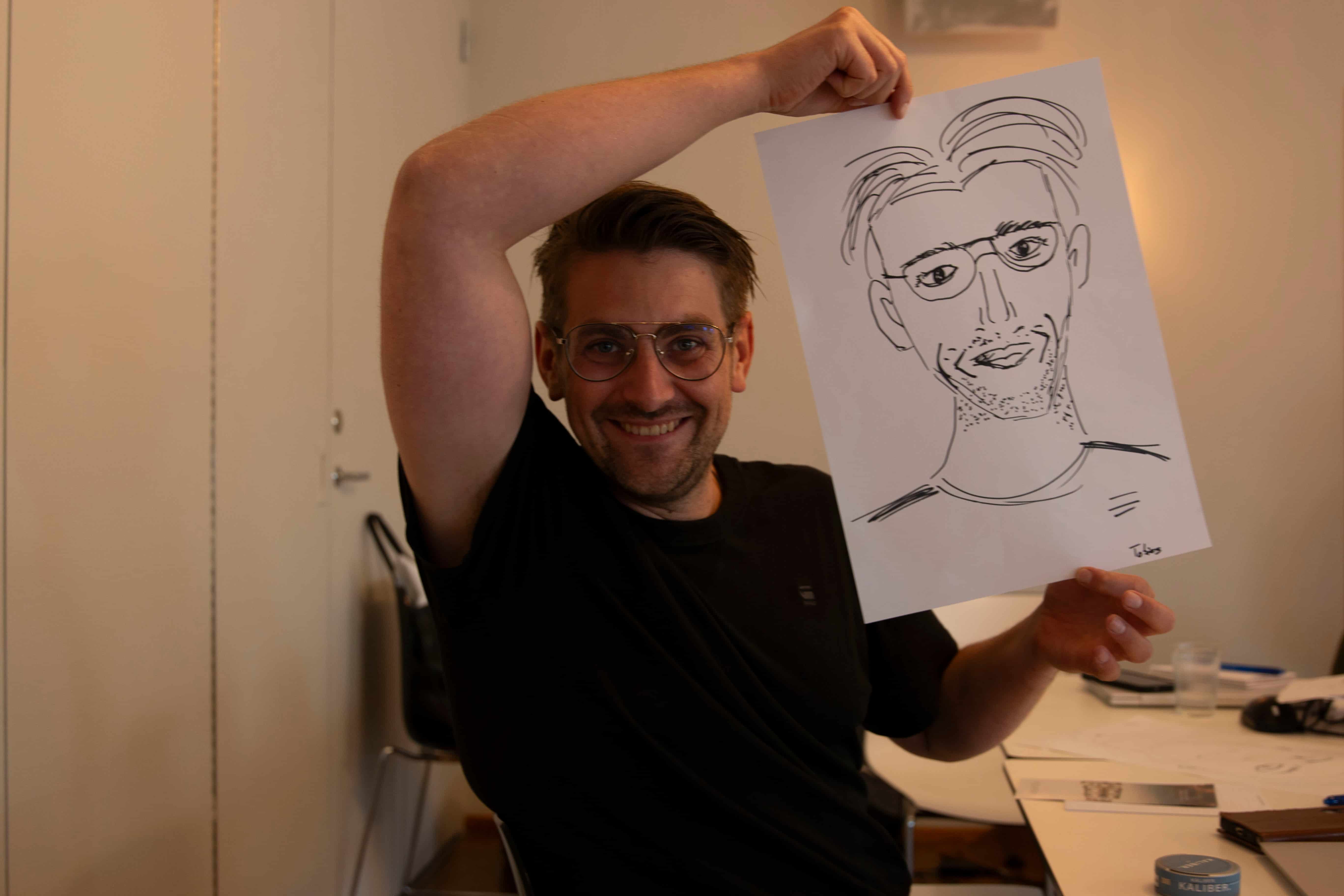 Team member showing a hand-drawn portrait during a workshop