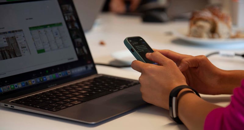 Zooma-person-sitting-at-desk-on-phone