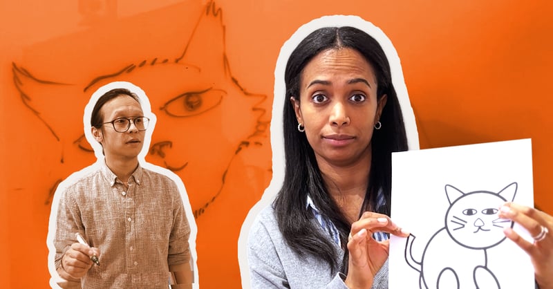 Two people standing together; one person is holding up a paper showing a drawing of a cat in front of her.